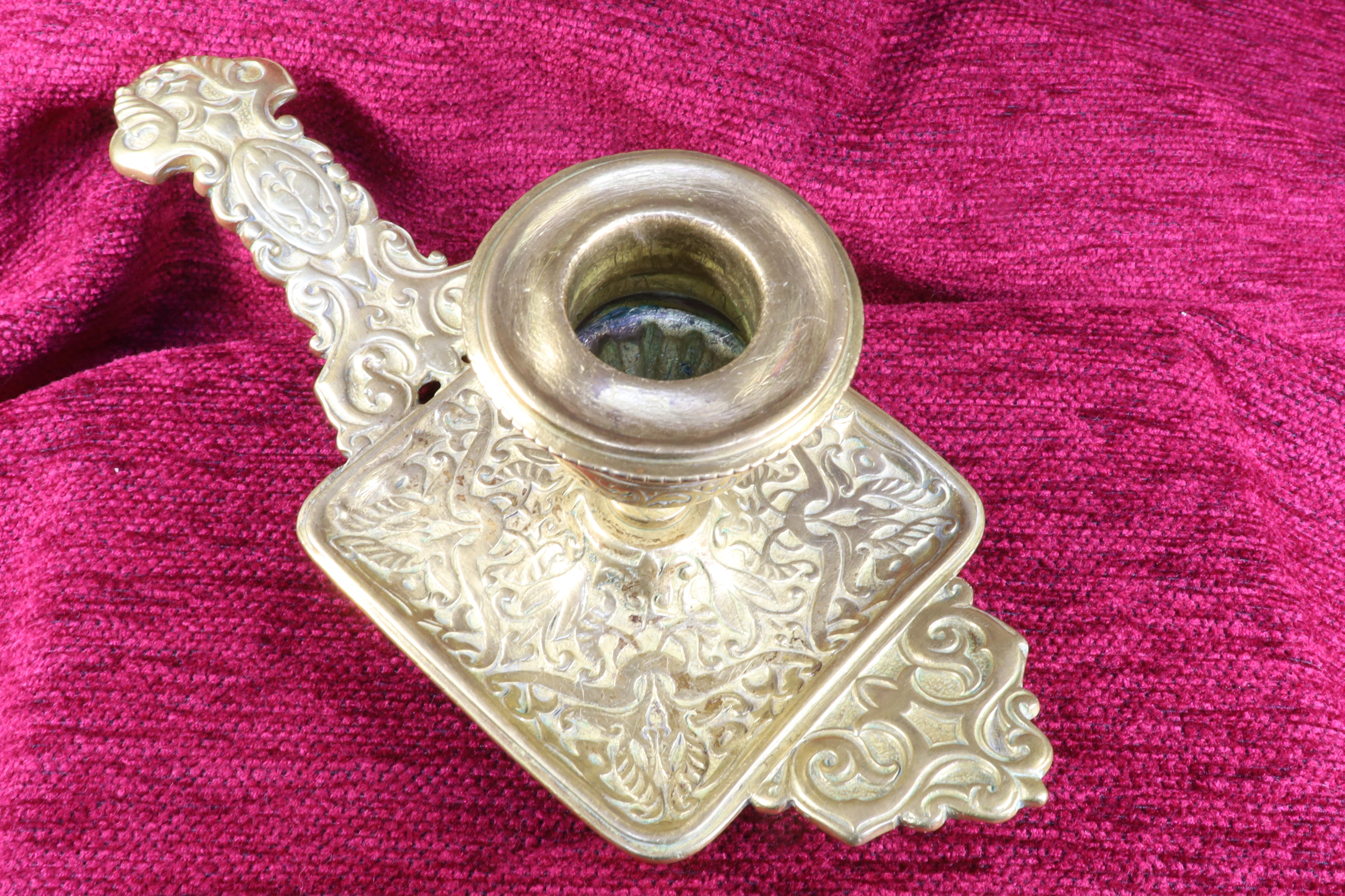 Antiques of chiseled bronze candlestick with legs